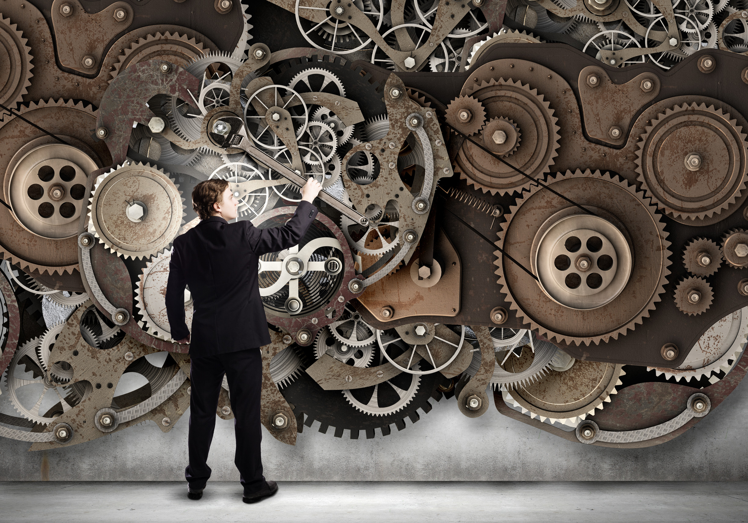 Image of business man working on the gears of his business